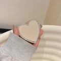 Detail of heart-shaped phone grip with beige lychee leather and sparkling rhinestones - Off White