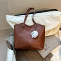 Brown leather tote bag with embossed patterns and a white pompom charm accessory - With Charm / Brown