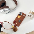 Custodia in pelle marrone con cuori 3D, cinturino a mano, campanellino e pompon - Marrone / iPhone 7/8/SE 2020
