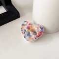 Macro detail of heart-shaped phone grip with colorful mosaic stone texture and white base - Colorful
