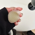 Detail of strawberry shaped phone grip with matte translucent texture in hand - Jasmine Green