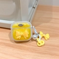 Detalle de funda AirPods amarilla brillante con lazo 3D, perla y placa de metal Happy - Lazo de Purpurina Amarillo Mágico / AirPods 1.ª/2.ª generación