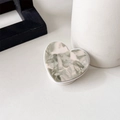 Macro shot of heart-shaped phone grip featuring green and white marble texture resin - Gray