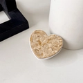 Detail of heart-shaped phone grip with light brown marble texture and white base - Khaki