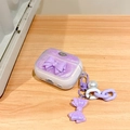 Detail of purple glitter AirPods case featuring 3D bow and pearl keychain accessory - Magic Purple Glitter Bow