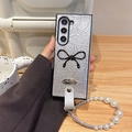 Detail of silver crinkled leather fold case with black bow and pearl wrist strap - Silver (Polka Dot Bow + Pearl Chain) / Samsung ZFlip3