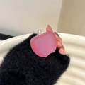 Detail of a pink matte apple-shaped hair clip held by hand against a soft background - Rose Red
