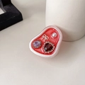 Dettaglio di strass a cuore, perla e gemma su supporto per cellulare in resina rossa - Fiocco Rosso Glitterato con Cuore di Rubino