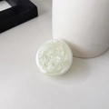 Macro view of light green pearlescent glitter phone socket grip on white desk - Jasmine Green