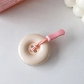 Dettaglio del supporto per telefono color crema a forma di bottone con laccio rosa - Bianco Sporco