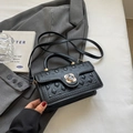 Black quilted crossbody bag with gold floral buckle and woven texture detailing - Black