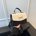 Minimalist beige straw and black leather crossbody bag with a gold bow buckle clasp - Black and White