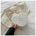 Detail der weißen Herz-Tasche mit schwarzer Spinnennetz-Stickerei und goldener Kette - Weiß