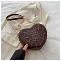 Detailed view of heart-shaped crossbody bag with spider web embroidery and chain strap - Brown