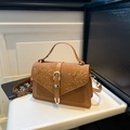 Brown snake-embossed crossbody bag with silver buckle and top handle on white surface - Brown