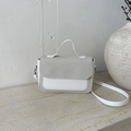 Minimalistische weiße und beige strukturierte Umhängetasche auf Steinfläche - Weiß
