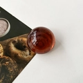 Macro shot of an amber translucent resin crystal ball phone grip with smooth surface - Transparent Brown