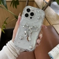 Custodia per iPhone con fiocco 3D argento e perline tenuta da un modello in scena reale - Guscio Crema - Goccia di Foglia d'Argento - Fiocco di Perle d'Argento / iPhone 7/8/SE 2020