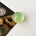 Detail view of a translucent light green crystal ball phone grip on a white background - Transparent Fluorescent Green