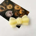 Dettaglio del supporto per telefono a fiocco in resina gialla traslucida con texture jelly - Giallo Pallido