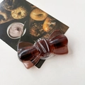 Gros plan d'un support de téléphone en forme de nœud marron foncé avec texture ambre - Marron Transparent