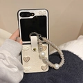 Dettaglio custodia in pelle Galaxy Z Flip con fiocco di perle, cuore e catenella - Bianco / Samsung ZFlip3