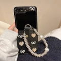 Dettaglio custodia in pelle nera con fiocco e cinturino di perle per Samsung Z Flip6 - Nero / Samsung ZFlip3