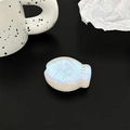 Macro shot of 3D fish phone grip with iridescent glitter finish on black background - White