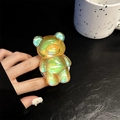 Macro shot of an iridescent bear-shaped phone grip with aurora rainbow finish - Dazzling Yellow