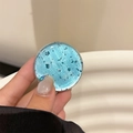 Blue glitter foil phone collapsible grip stand shown held in hand with macro detail - Sky Blue