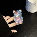 Close-up of laser aurora bear phone grip held in hand with holographic resin finish - Dazzling Light Blue