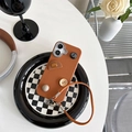 Detalle de funda de cuero marrón con botones geométricos y correa de muñeca elegante - Marrón / iPhone 14Plus/15Plus
