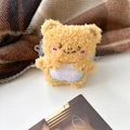 Detail of yellow plush bear earphone case with soft sherpa texture and cute embroidery - Cream Apron Bear Back Clip