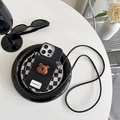 Detalle de funda negra con oso 3D y correa cruzada sobre un plato de cuadros moderno - Negro / iPhone 7/8/SE 2020