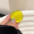 Detail of yellow resin phone grip with embedded gold leaf and small teardrop charm - Yellow