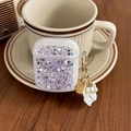Close-up of AirPods case with silver glitter, purple sequins and pearl shell keychain charm - Purple / AirPods 1/2 Gen