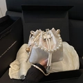 Elegant satin bucket bag with floral embroidery and pearl handle on a luxury gift box - White