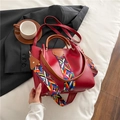 Red leather handbag with colorful geometric woven strap and brown handles for women - Red