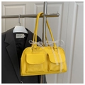 Detail of yellow shoulder bag featuring front flap pockets and white lace bow decoration - Yellow