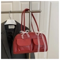Detail of red vintage boston bag featuring front flap pockets and white lace bow decor - Red