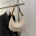 Handwoven cream straw hobo bag with knotted brown leather shoulder strap shown on hanger - Brown
