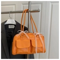 Détail du sac Boston orange avec poches avant et nœuds en dentelle sur cuir synthétique - Orange