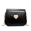 Modern black crossbody bag with a golden heart clasp and chain strap on white background - Black