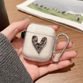 Detalle de funda transparente para AirPods con corazón de metal plateado y mosquetón - Corazón arrugado con purpurina (Transparente) / AirPods 1.ª/2.ª generación