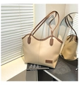 Detail of beige tote bag featuring brown leather trim and fashion label on front - Khaki