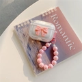 Durchsichtige AirPods-Hülle mit rosa Schleife und Perlenarmband auf Notizblock - 1./2. Gen Universal / Transparent Rosa Schleife (Rosa Perlenkette)