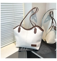 Detail of white leather tote bag featuring brown contrast trim and brand label - Off White