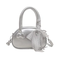 Sac à main en cuir argenté avec nœuds décoratifs et détails en dentelle sur fond blanc - Avec Pendentif / Argenté