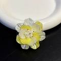 Close-up of a shell flower phone grip with pearl center and yellow-white petals - Adhesive Type / Amber White