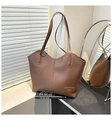 Macro detail of high-quality brown PU leather texture and debossed metal brand plate - Brown